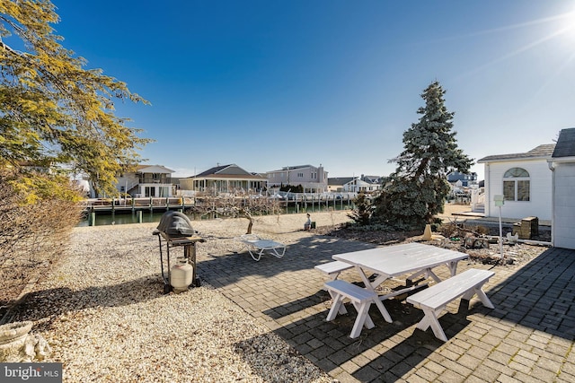 view of yard featuring outdoor dining space, a patio area, and a residential view