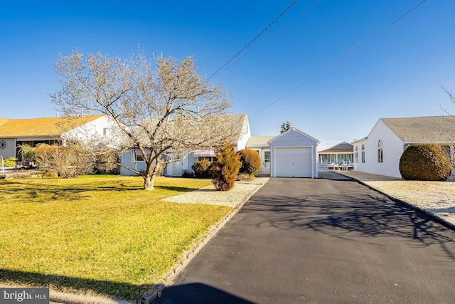 single story home with aphalt driveway, a garage, and a front yard