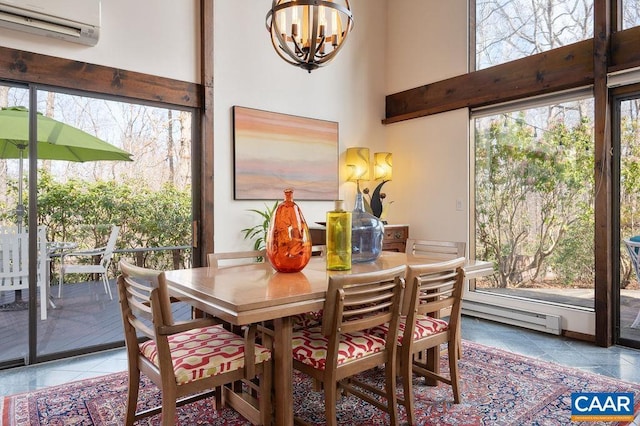 tiled dining space with a notable chandelier, a baseboard heating unit, a wall unit AC, and a towering ceiling