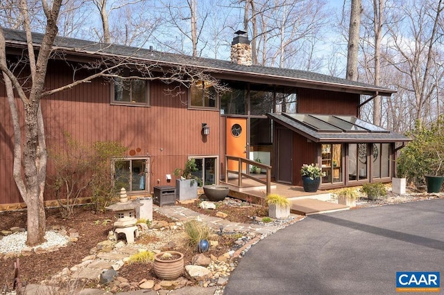 view of front of property with a chimney and roof with shingles