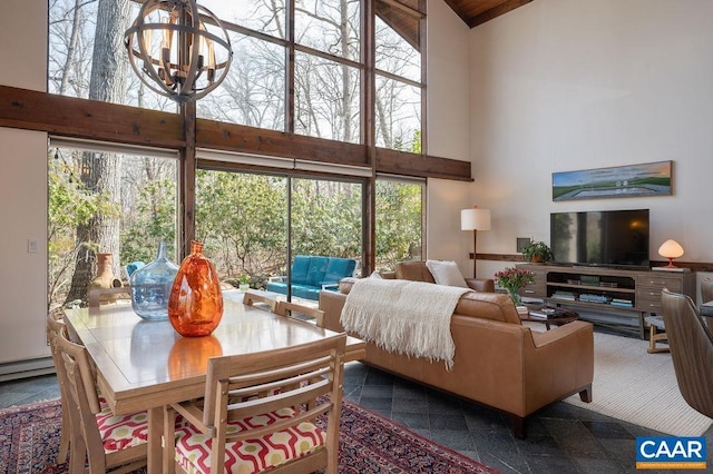 living room featuring a high ceiling, a chandelier, and granite finish floor