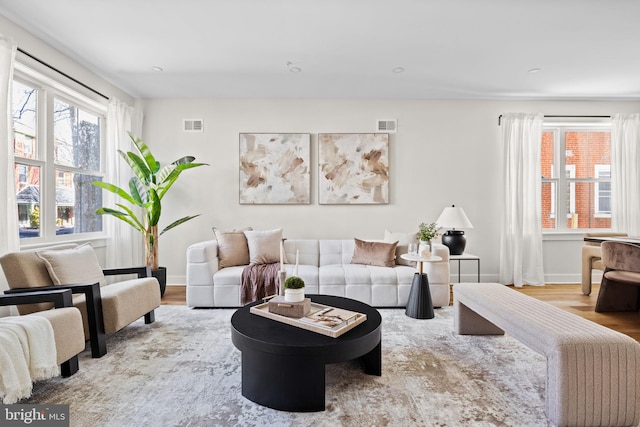 living room with visible vents, baseboards, and wood finished floors