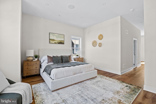 bedroom with wood finished floors and baseboards