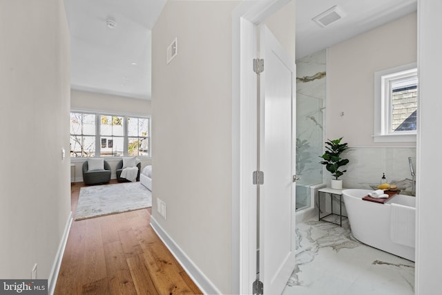 hall featuring visible vents, marble finish floor, and baseboards