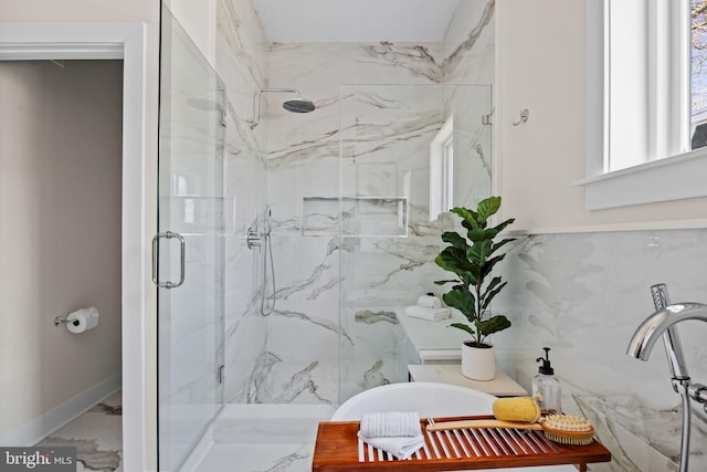 full bathroom with marble finish floor, a marble finish shower, and a freestanding bath