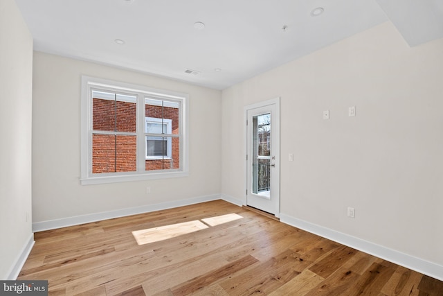 unfurnished room featuring visible vents, baseboards, and light wood-style floors