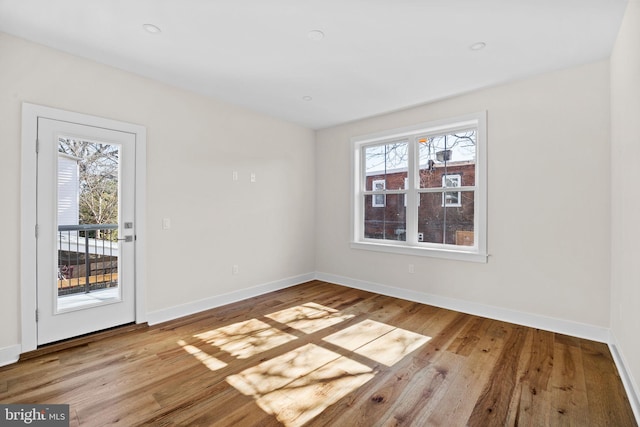 empty room with baseboards and wood finished floors