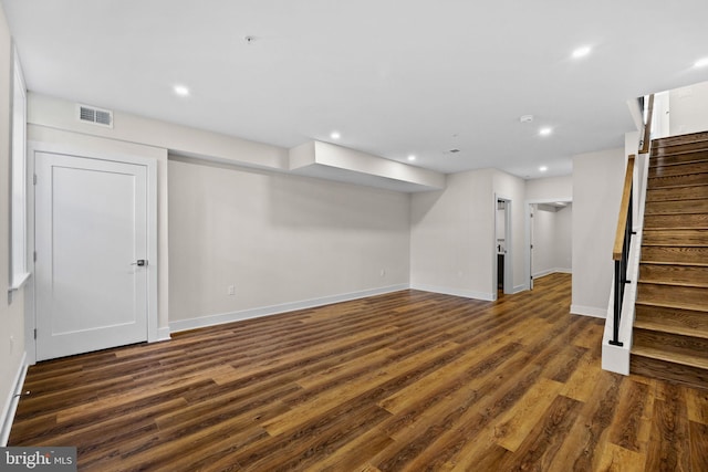 finished basement with visible vents, baseboards, dark wood finished floors, stairway, and recessed lighting