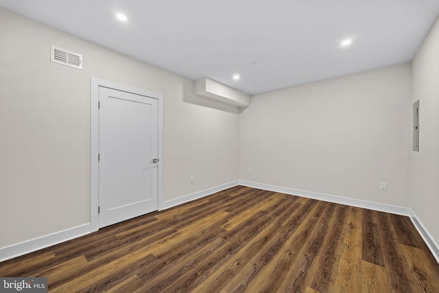 below grade area with dark wood finished floors, baseboards, and visible vents