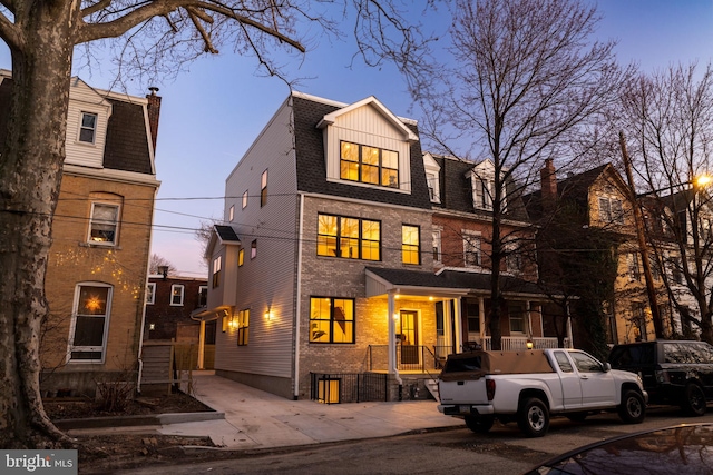 view of front of property with brick siding and a shingled roof