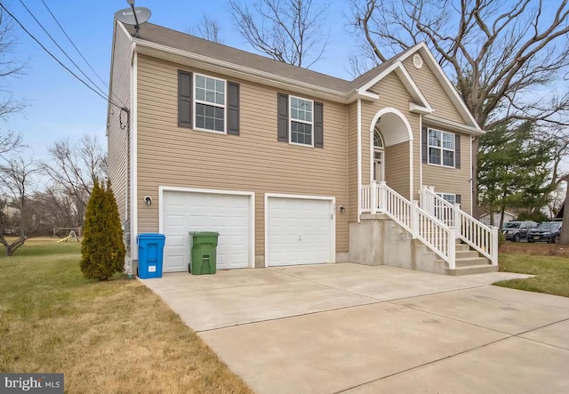 split foyer home featuring a garage, concrete driveway, and a front yard