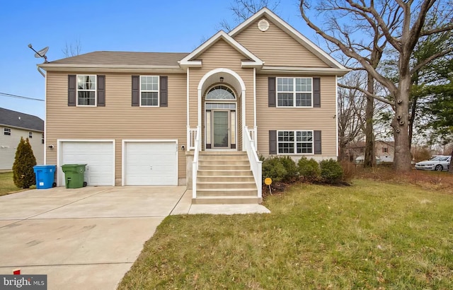 raised ranch with an attached garage, concrete driveway, and a front lawn