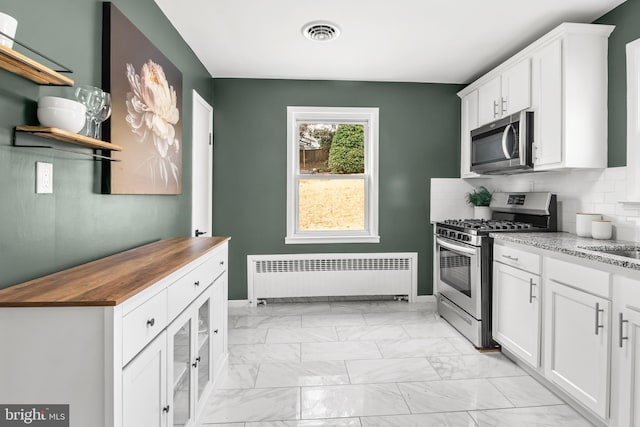 kitchen featuring radiator, visible vents, appliances with stainless steel finishes, wood counters, and marble finish floor