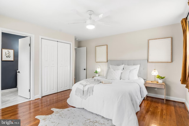 bedroom featuring a closet, a ceiling fan, baseboards, and wood finished floors