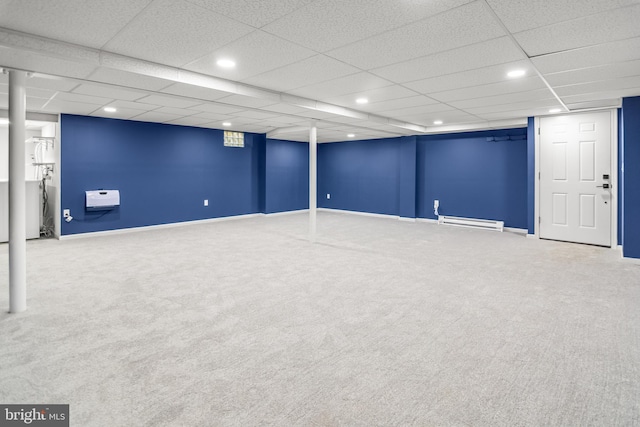 finished basement featuring recessed lighting, carpet floors, a paneled ceiling, baseboards, and baseboard heating