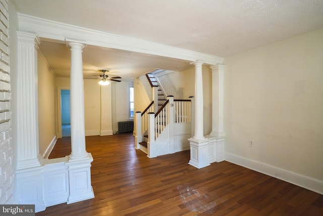 interior space with stairs, radiator, wood finished floors, and ornate columns