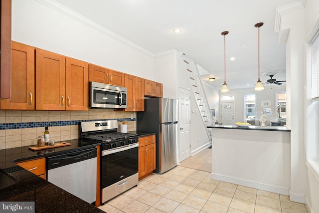 kitchen featuring brown cabinets, pendant lighting, ornamental molding, stainless steel appliances, and decorative backsplash