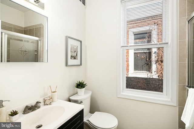 full bathroom with a fireplace, toilet, a stall shower, and vanity