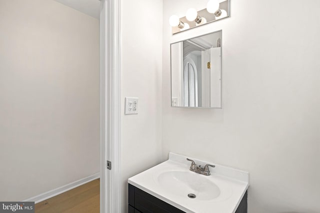 bathroom featuring vanity, baseboards, and wood finished floors