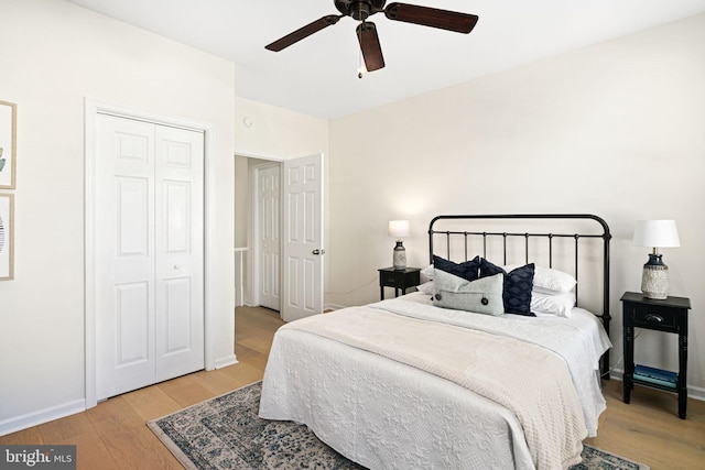 bedroom featuring a closet, baseboards, light wood-style floors, and ceiling fan