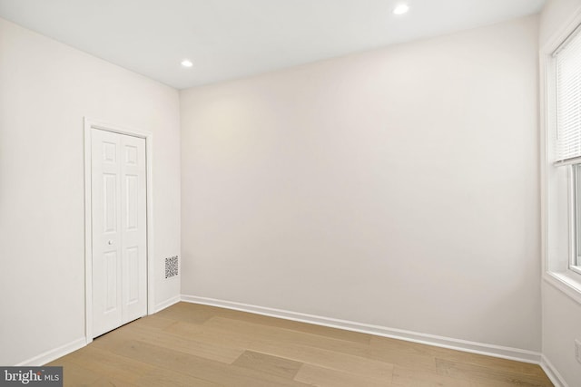 empty room featuring recessed lighting, baseboards, and light wood-style floors