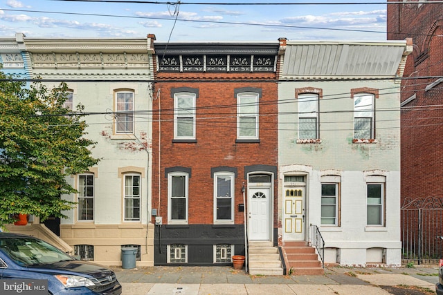 view of property with entry steps, brick siding, and central AC