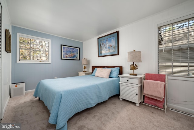 carpeted bedroom featuring crown molding and visible vents