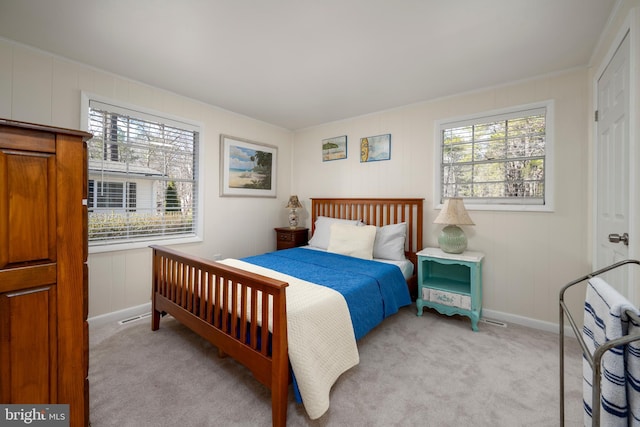 bedroom with multiple windows, baseboards, and light carpet