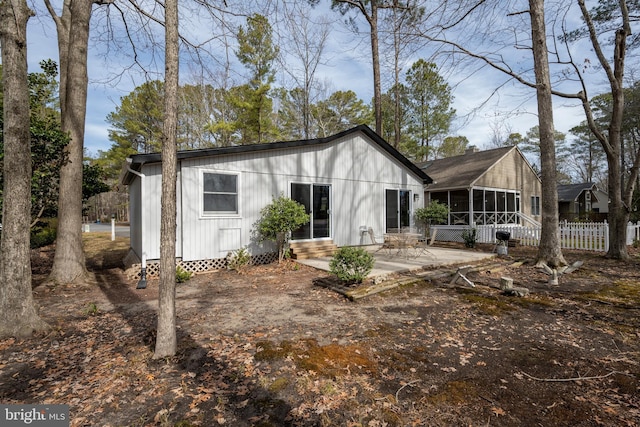 back of house featuring a sunroom, fence, a patio, and entry steps