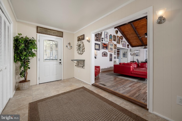 tiled entryway featuring wood ceiling, crown molding, and vaulted ceiling