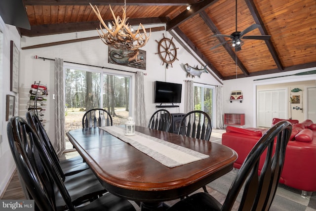 dining area featuring wooden ceiling, beamed ceiling, ceiling fan with notable chandelier, and high vaulted ceiling