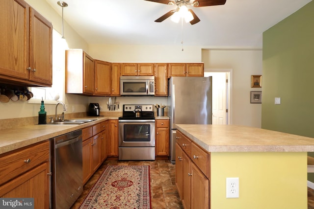 kitchen featuring a sink, stainless steel appliances, light countertops, brown cabinets, and a center island