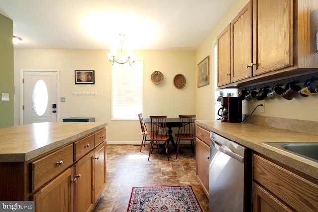 kitchen with brown cabinets, stone finish flooring, an inviting chandelier, baseboards, and dishwasher