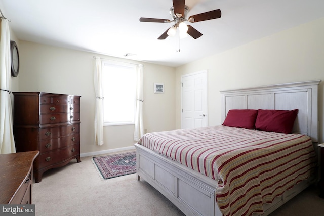 bedroom featuring a ceiling fan, light colored carpet, and baseboards