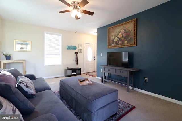 carpeted living room featuring baseboards and a ceiling fan