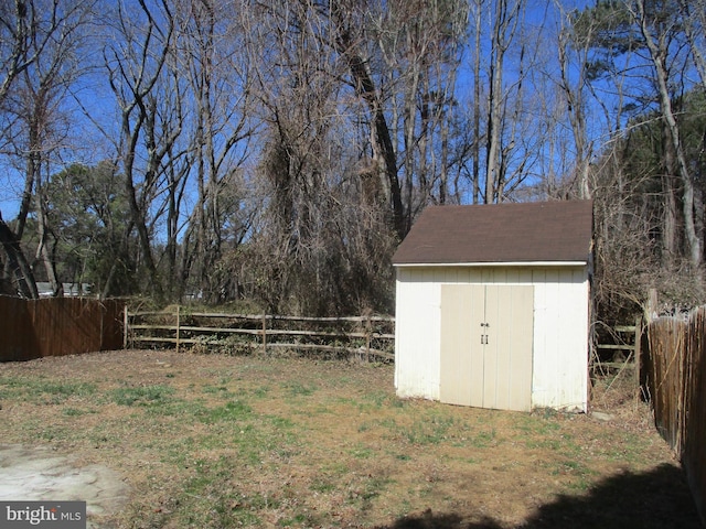 view of yard with an outbuilding, a storage shed, and a fenced backyard