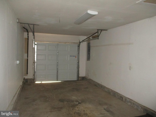 garage featuring electric panel and baseboards