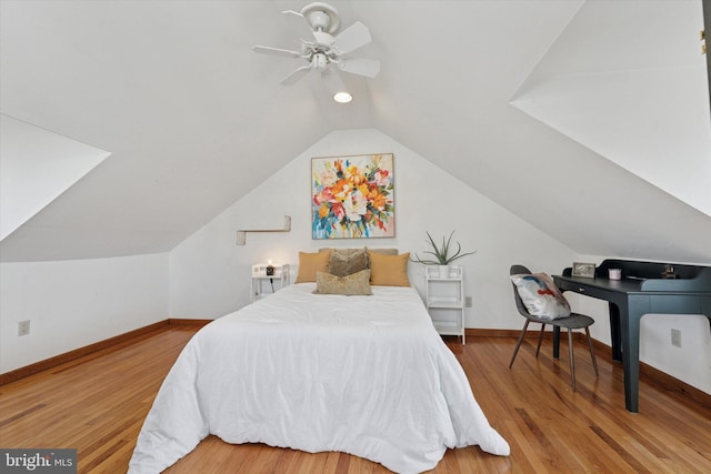 bedroom with vaulted ceiling, ceiling fan, baseboards, and wood finished floors