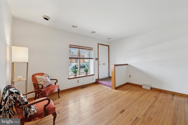 sitting room featuring visible vents, baseboards, and light wood-style floors