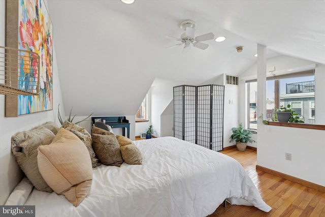 bedroom with multiple windows, lofted ceiling, baseboards, and wood-type flooring