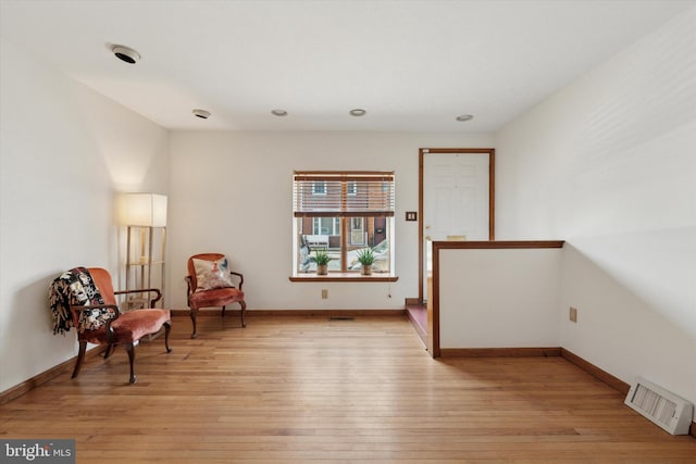 sitting room featuring baseboards, visible vents, and light wood-type flooring