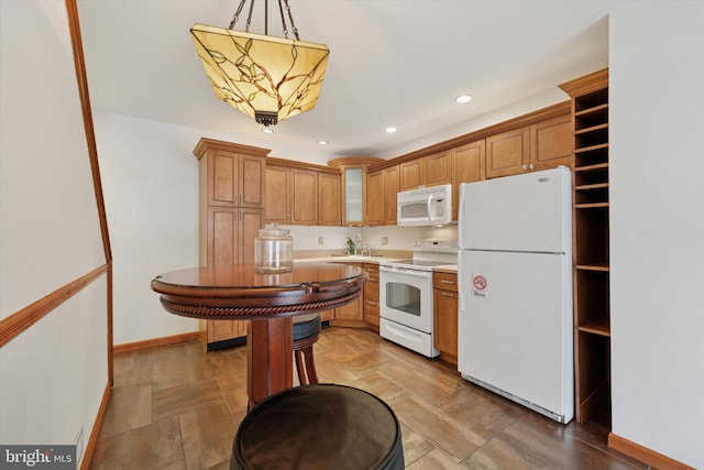 kitchen featuring pendant lighting, recessed lighting, white appliances, light countertops, and baseboards