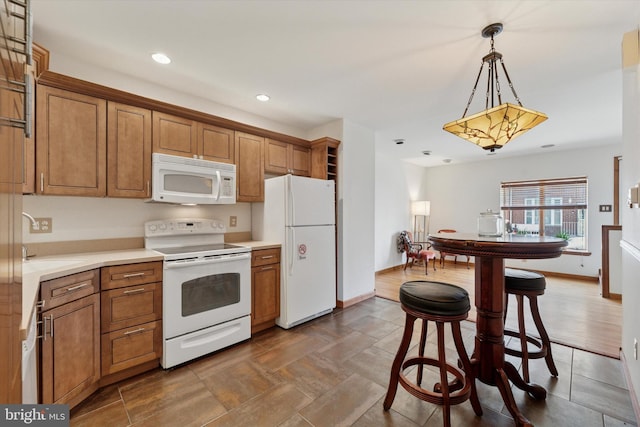 kitchen featuring a sink, white appliances, and brown cabinetry