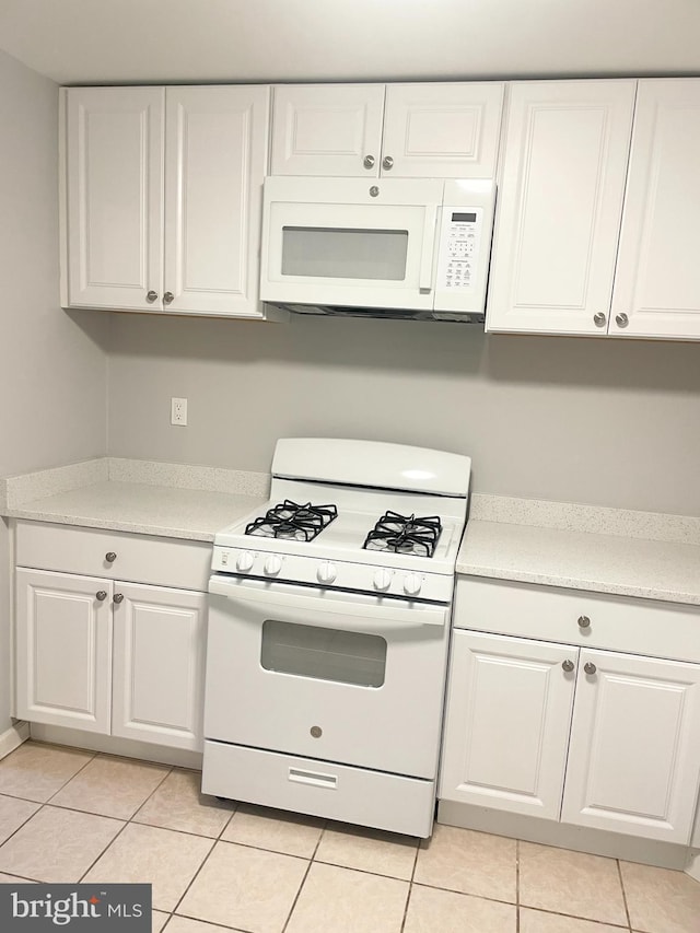 kitchen featuring light tile patterned flooring, white cabinets, white appliances, and light countertops