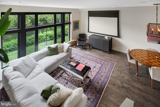 living area featuring an inviting chandelier, baseboards, and wood finished floors