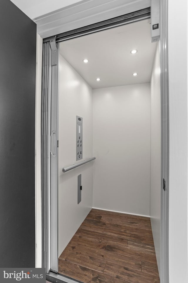 details with recessed lighting, elevator, and wood finished floors