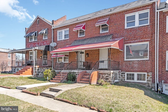 townhome / multi-family property featuring brick siding and a front lawn