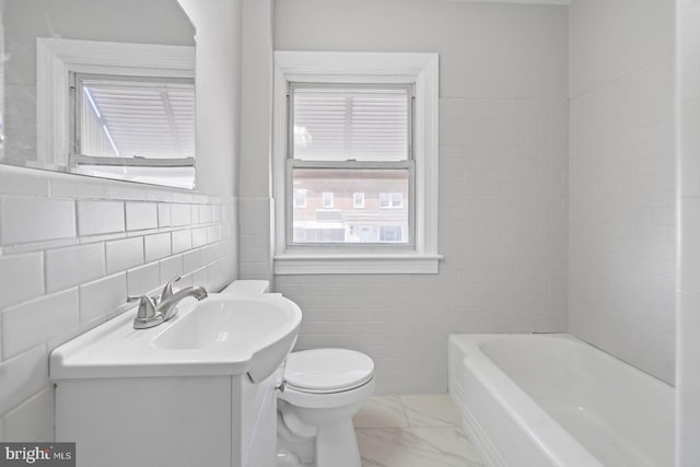 full bathroom featuring vanity, a tub to relax in, tile walls, toilet, and marble finish floor