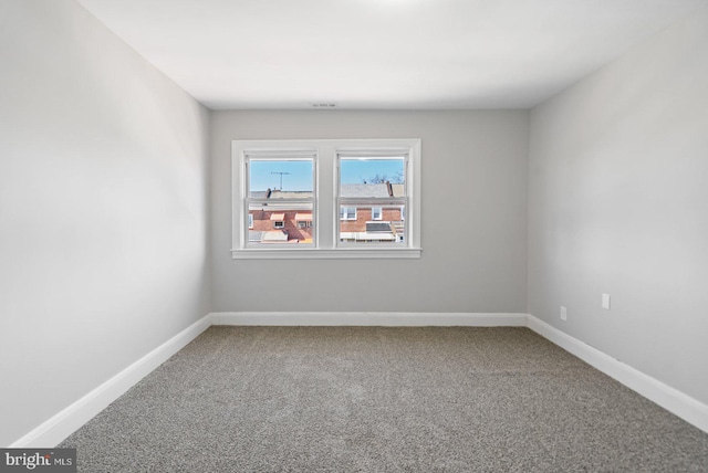 spare room with baseboards and carpet floors