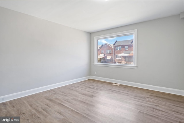 empty room with baseboards and wood finished floors